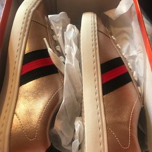 Gold sneakers with stripes on the side